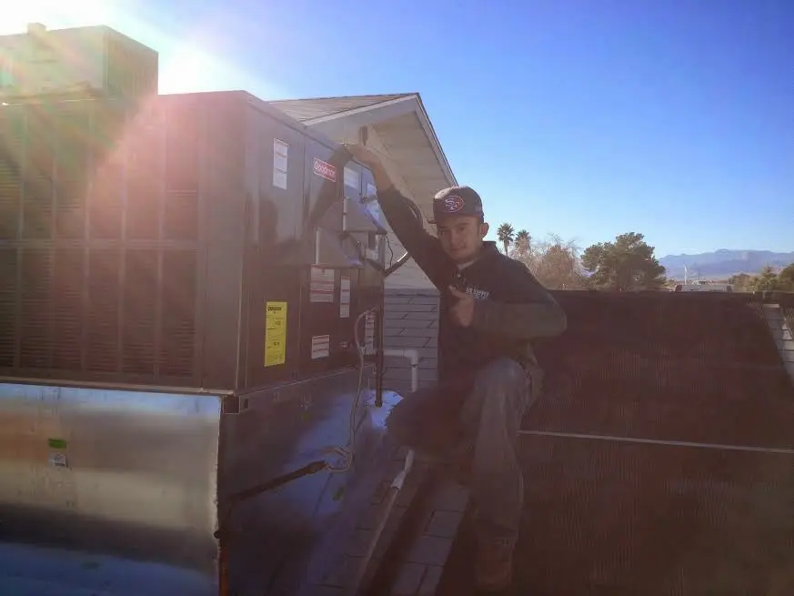 HVAC technician performing HVAC Inspection on a rooftop unit in Simsbury